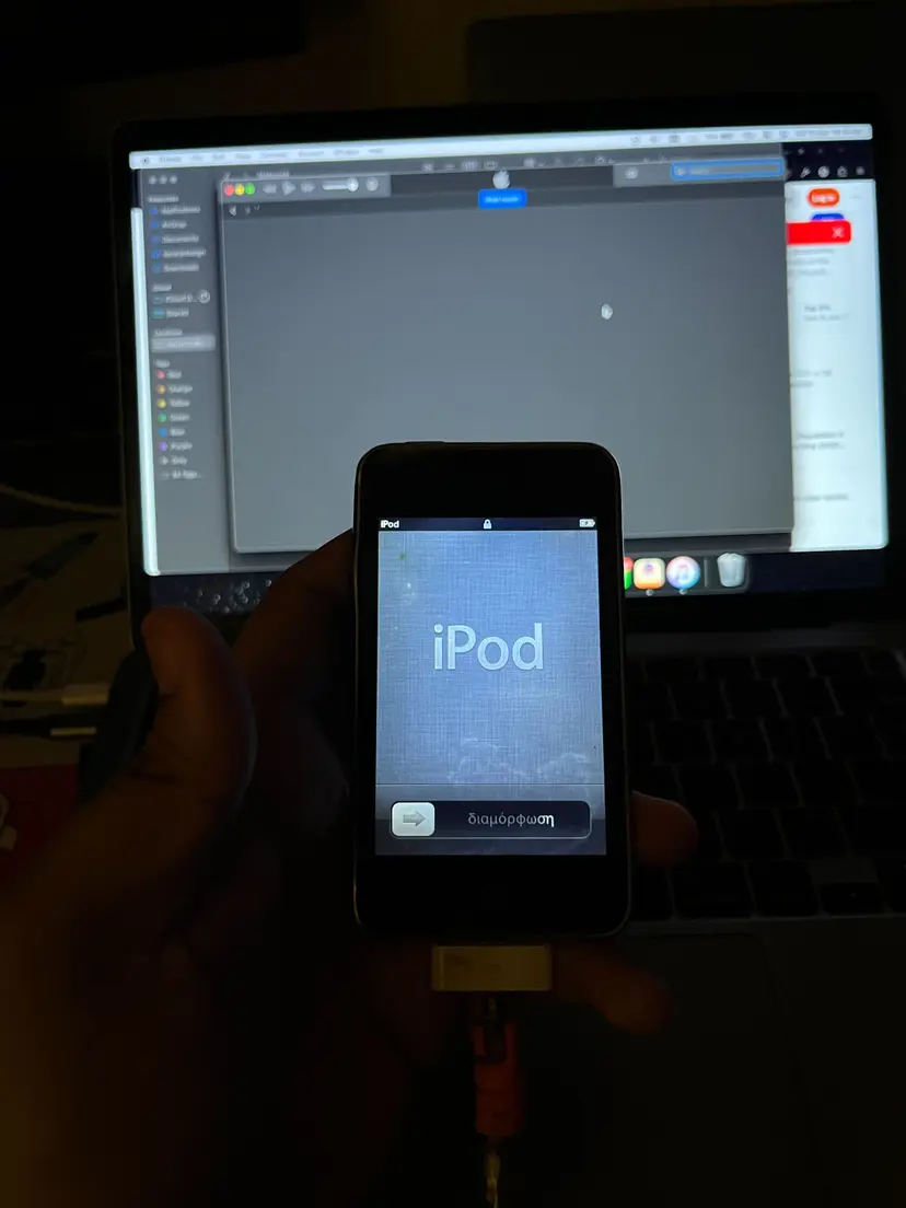 Old iPod being jailbroken with recovery mode screen and connected cables